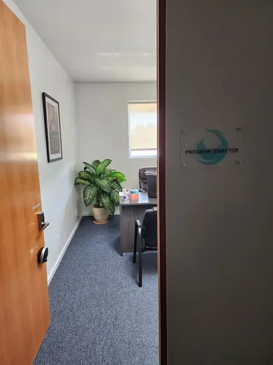 Bright office space with a plant at West LA Recovery, a sober living home in Los Angeles.